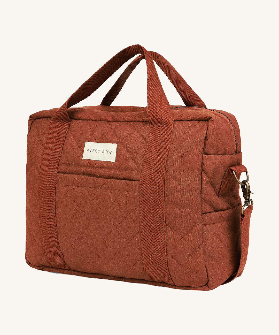 A orange and brown cinnamon coloured Avery Row baby changing bag on a cream background.