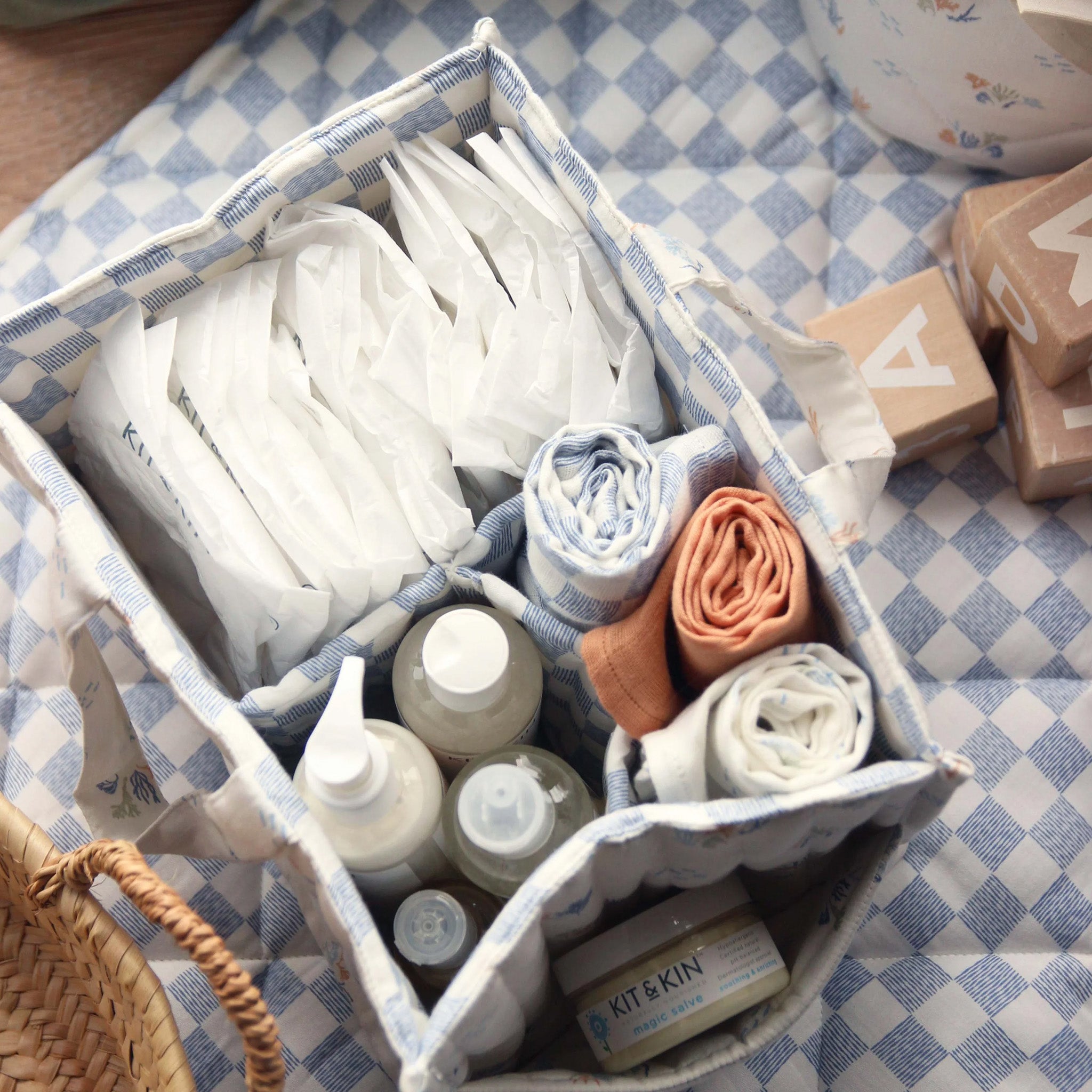 A person holding the handles of the Avery Row Organic Cotton Nappy Caddy Organiser - Coastlines