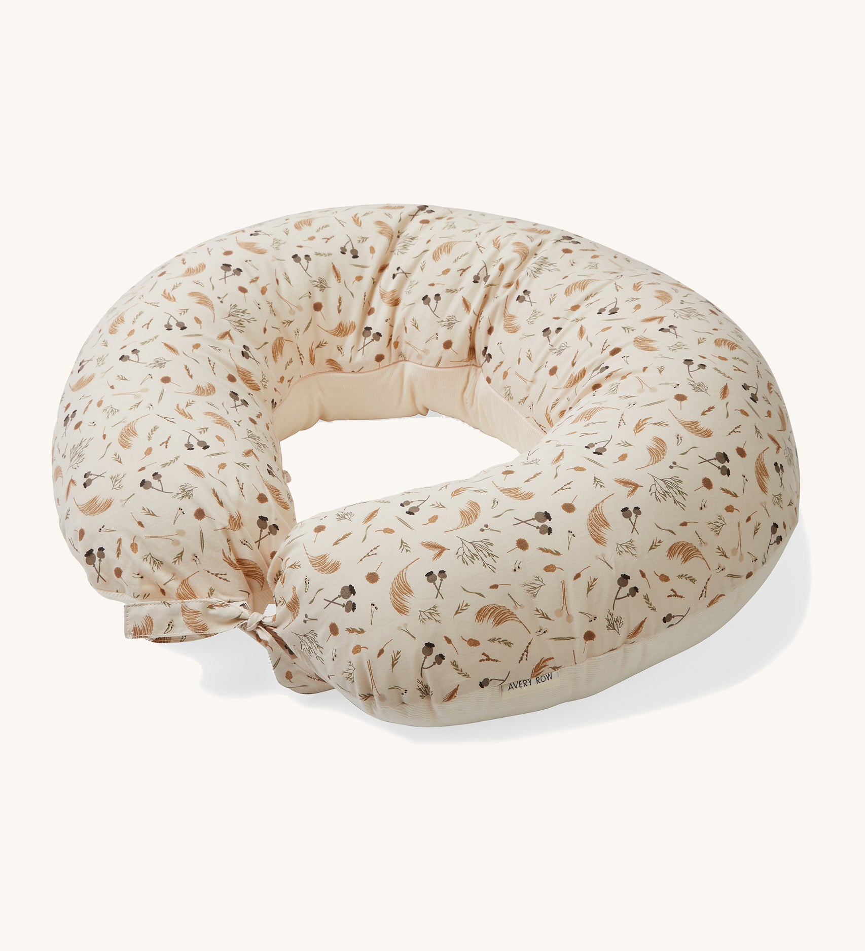 A soft light cream Avery Row nursing pillow with a grassland design on a cream background.