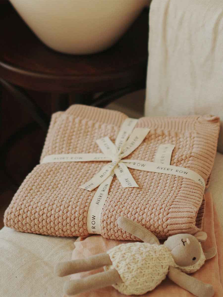 a lilac pink chunky knit blanket tied with an Avery Row ribbon