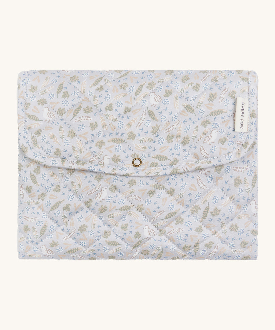 A soft light blue coloured Avery Row travel changing mat with a nature design on a cream background.