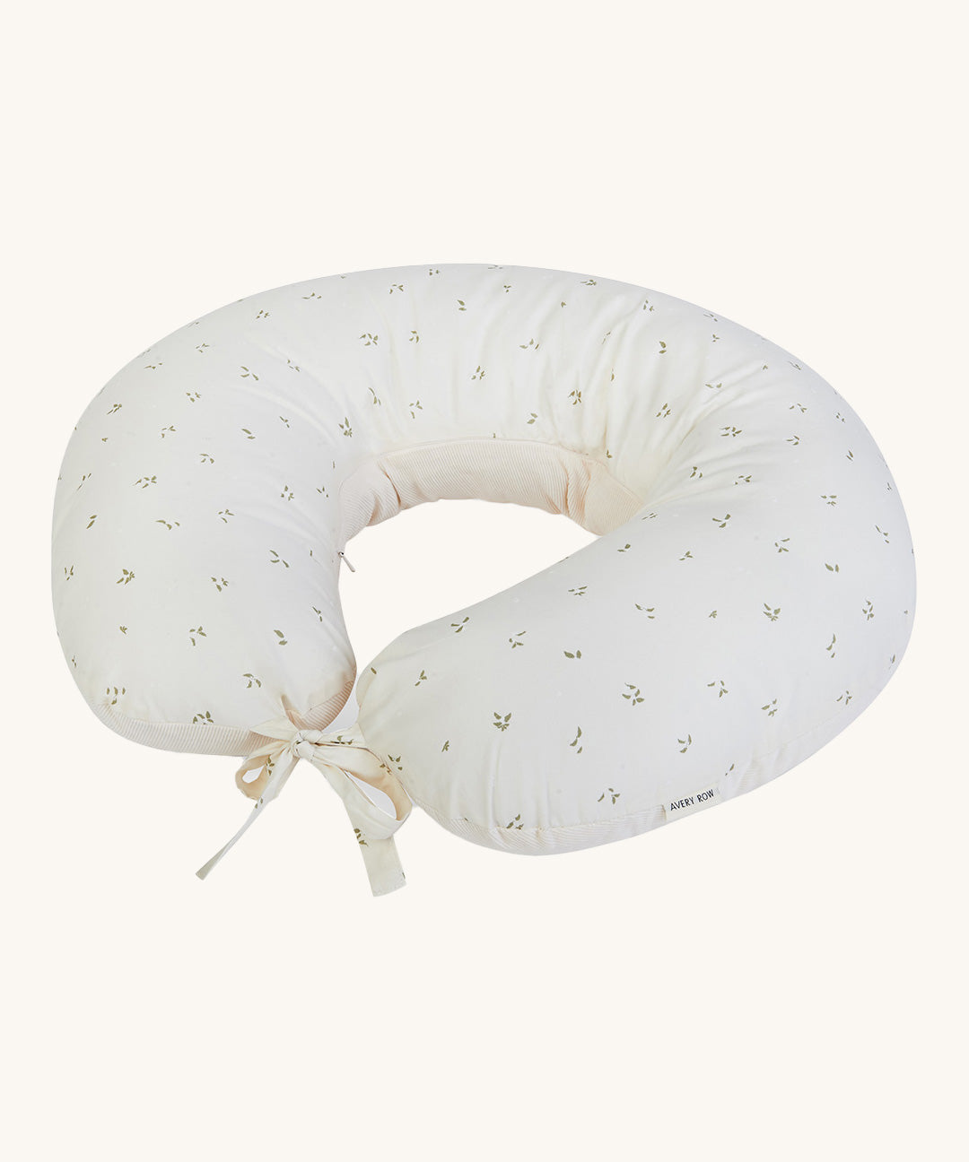 A soft light coloured Avery Row nursing pillow with a nettle design on a cream background.