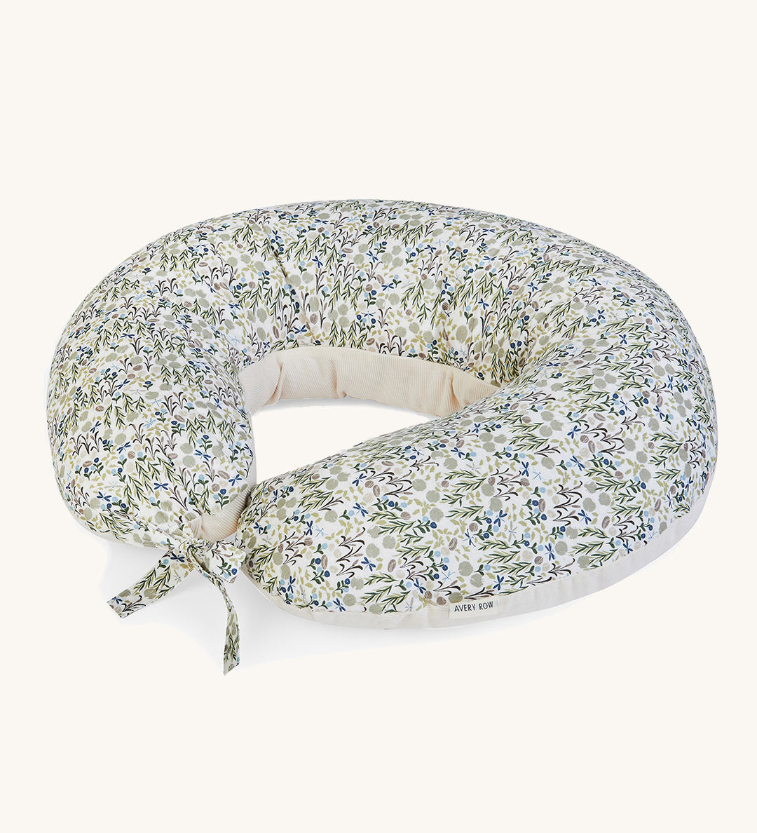 A soft Avery Row nursing pillow with a flower design on a cream background.