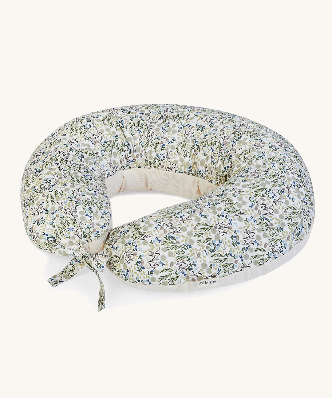 A soft Avery Row nursing pillow with a flower design on a cream background.