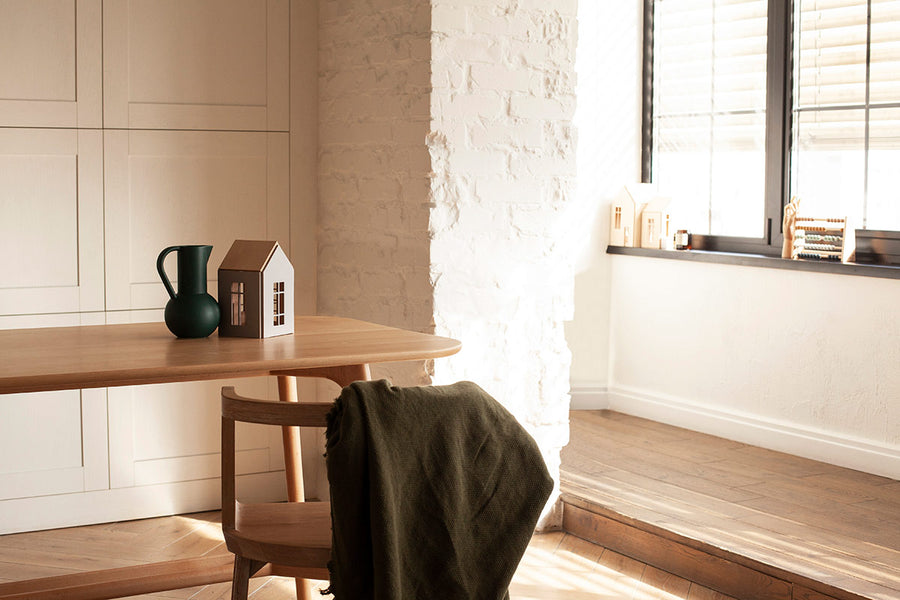 Babai sustainable magnetic wooden dollhouse toys on a wooden kitchen table in a white dining room