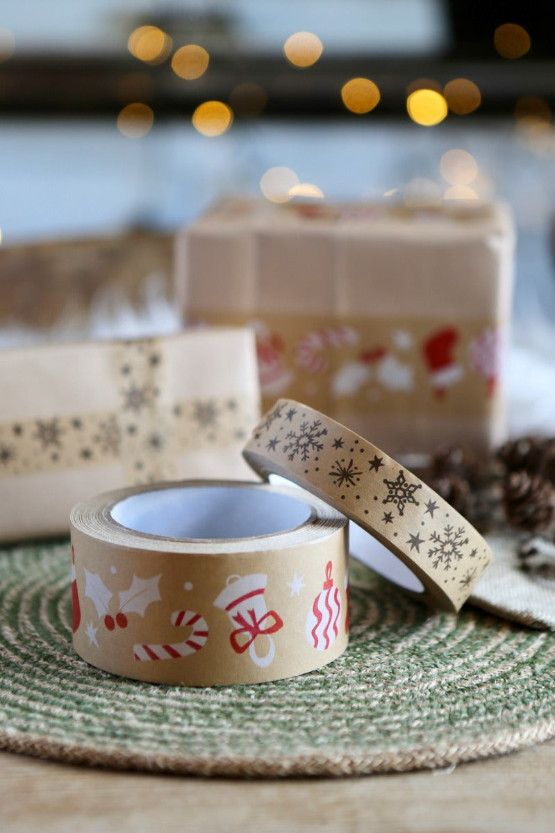 Close up of the Babipur eco kraft paper tape in the Christmas prints on a green placemat next to some Christmas presents