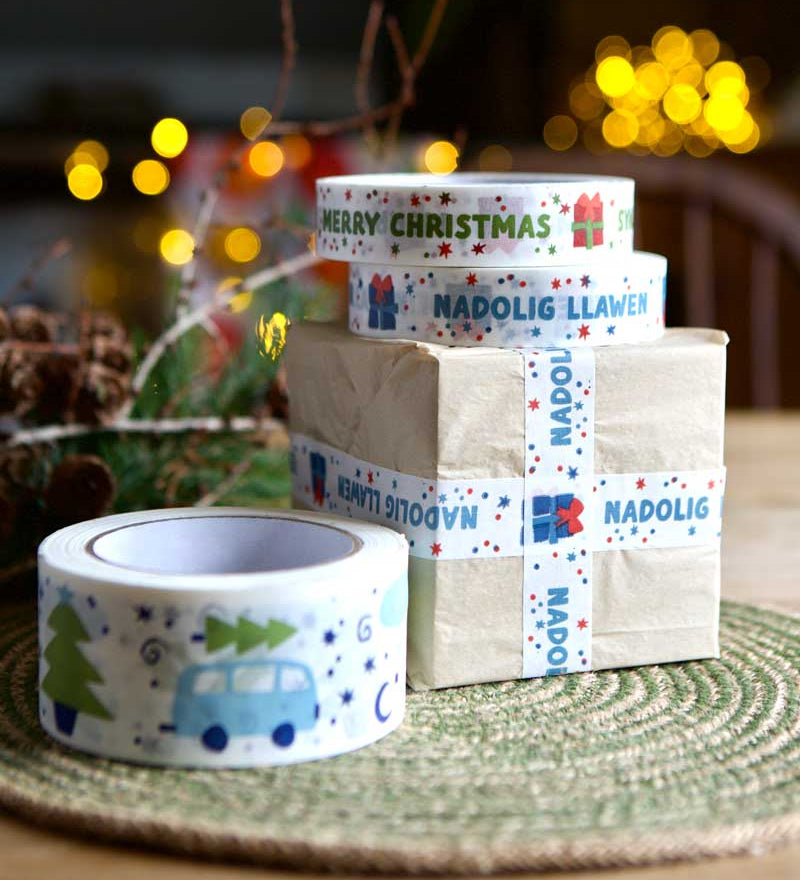 Babipur Christmas design eco paper tapes with a brown paper wrapped package decorated with the Welsh Nadolig Llawen design paper tape