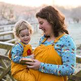 Woman carrying a little boy wearing matching Babipur x Frugi eco-friendly childrens and adults Babipur World tops