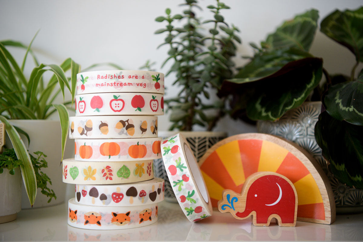 A stack of Babipur autumn paper tape on a shelf. There are plants in the background.