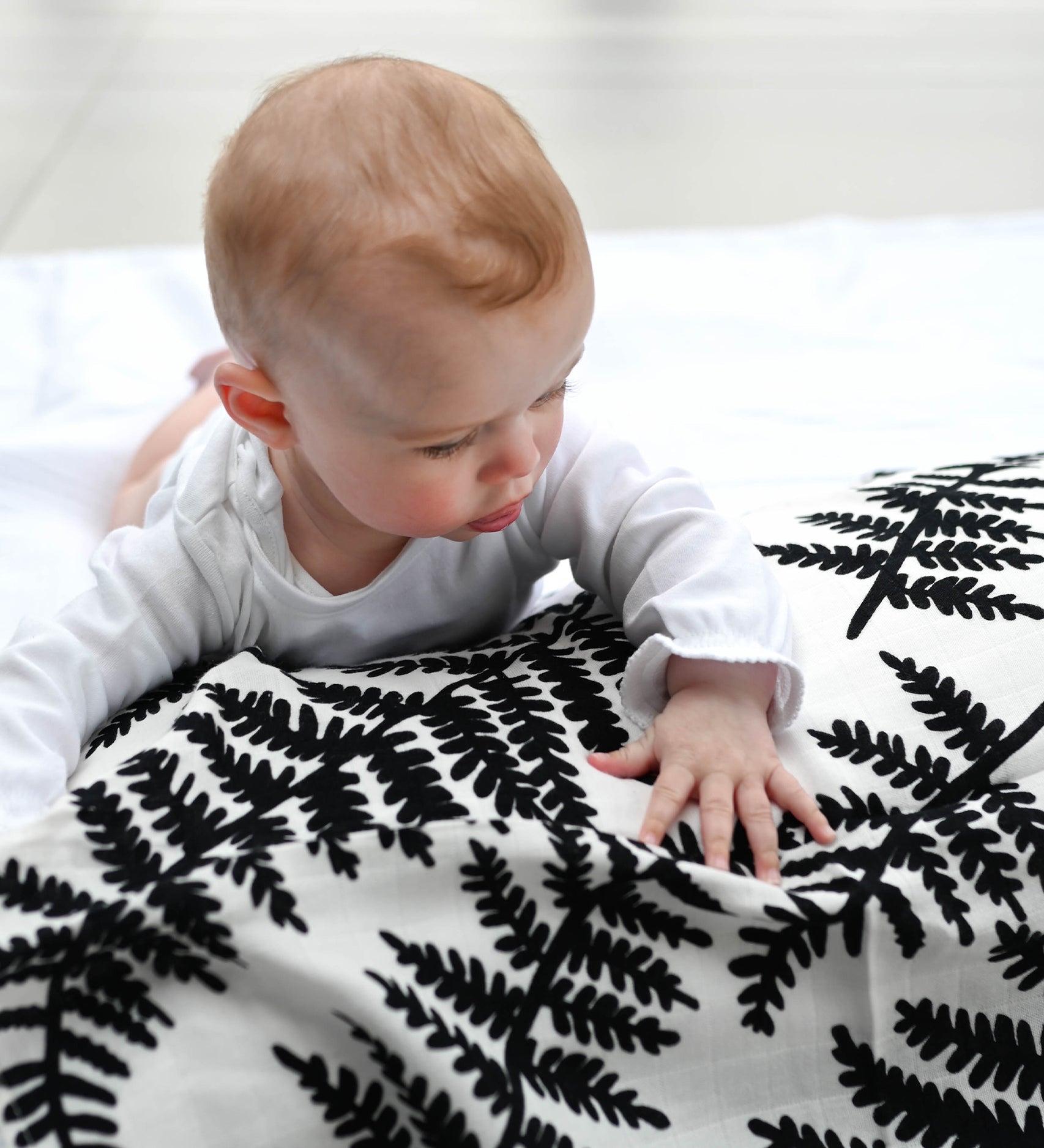  made from GOTS organic cotton with a black leafy fern print. On a cream background