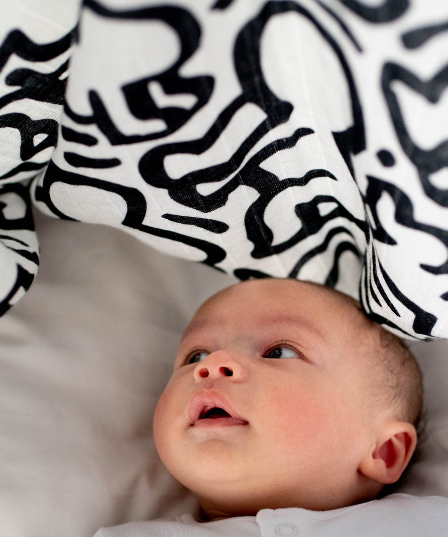  and looking up at the The Etta Loves X Keith Haring Extra Large Organic Cotton Baby Muslin Square - Baby