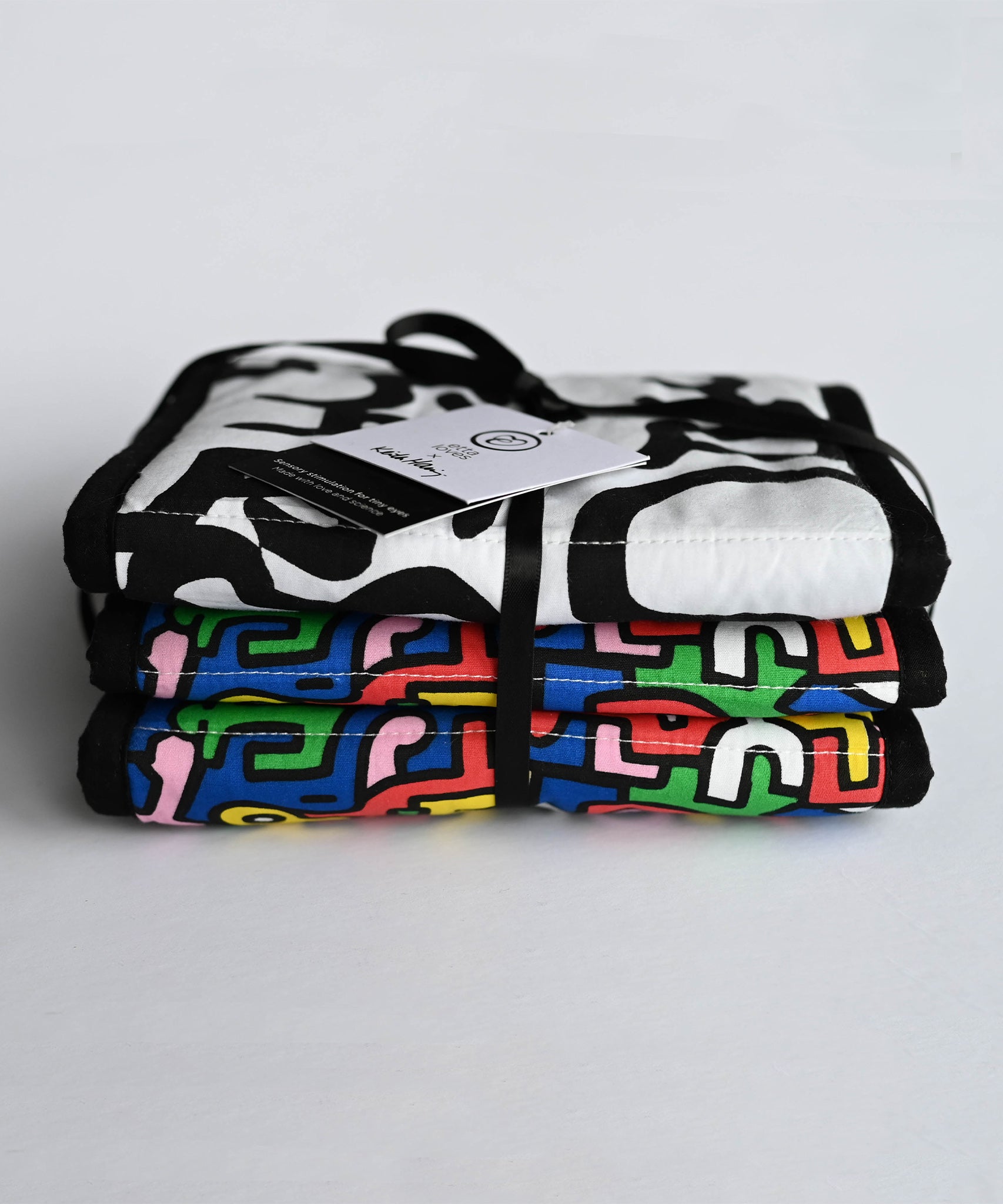 A child look at the 'Brazil' print on the Etta Loves X Keith Haring Reversible Baby Sensory Strip