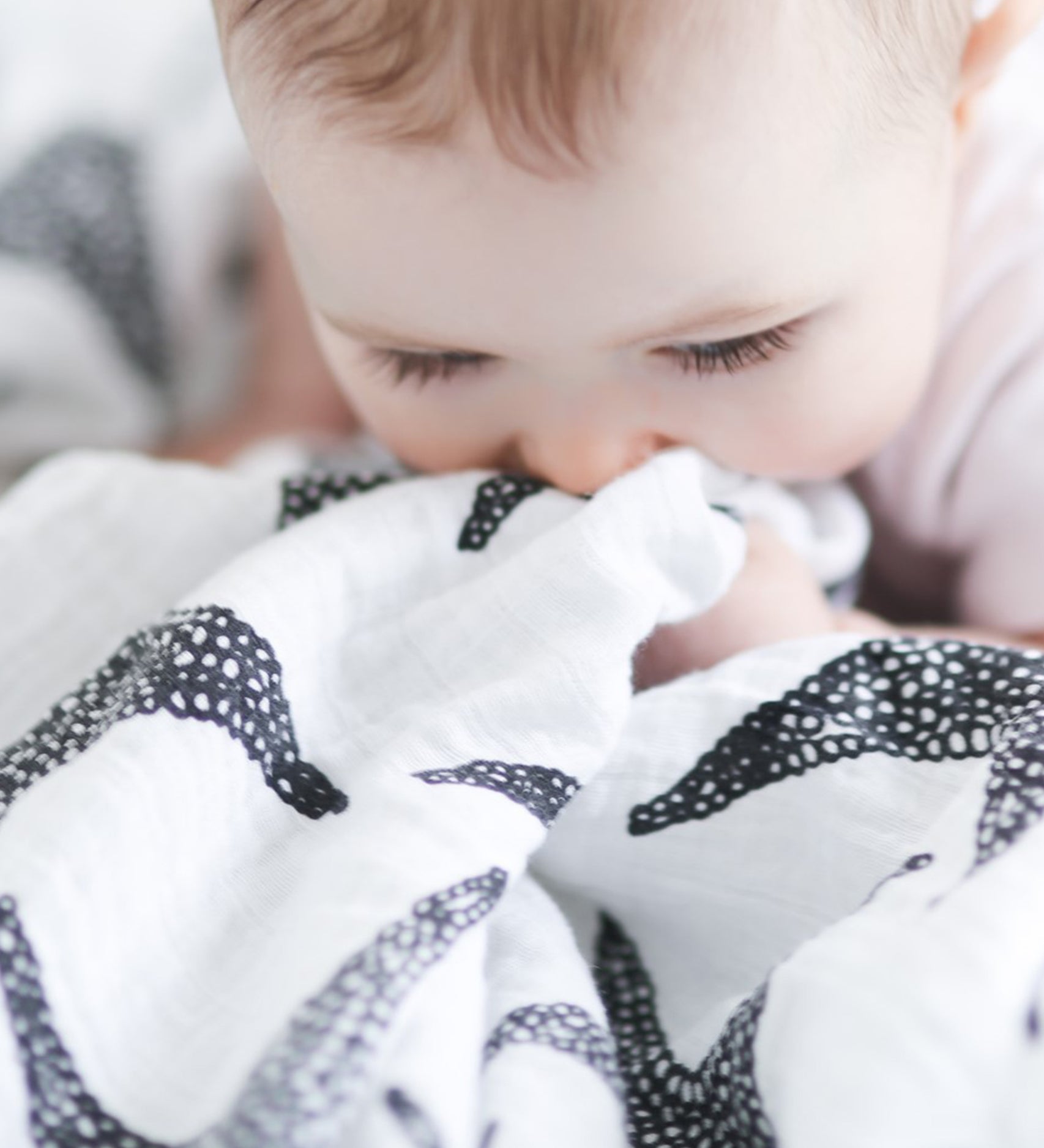 A child grasping the XL Starfish muslin cloth 