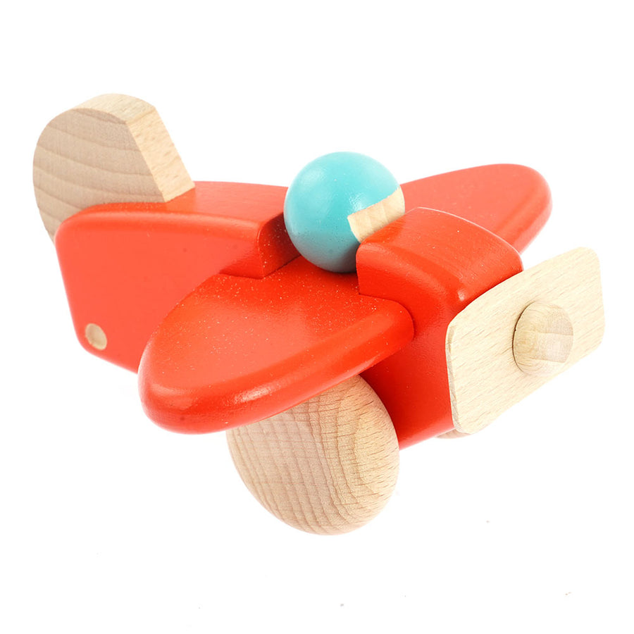 Bajo children's handmade wooden plane with pilot toy in the coral colour on a white background