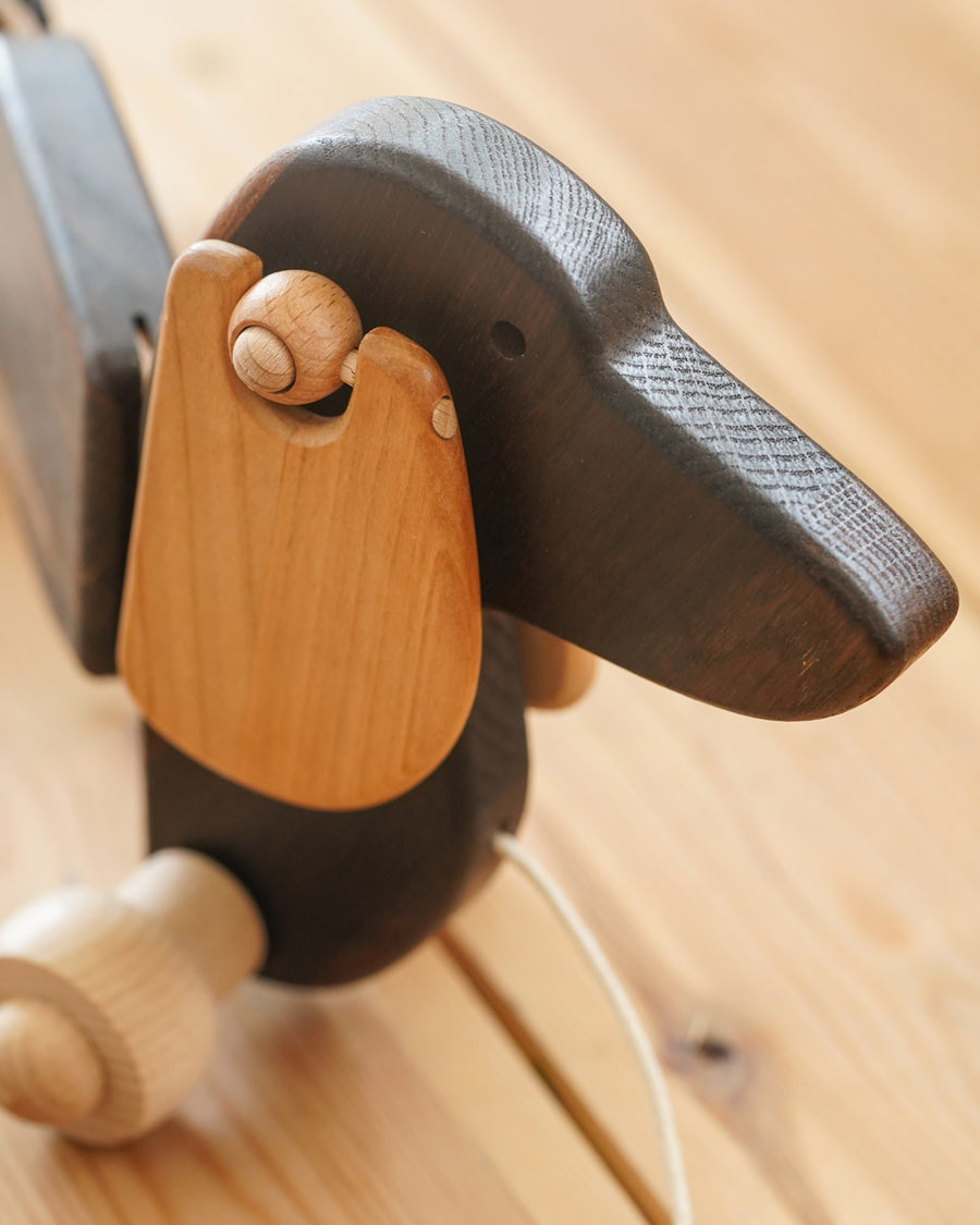 Close up of the floppy wooden ears on the Bajo dark oak pull along toy dog