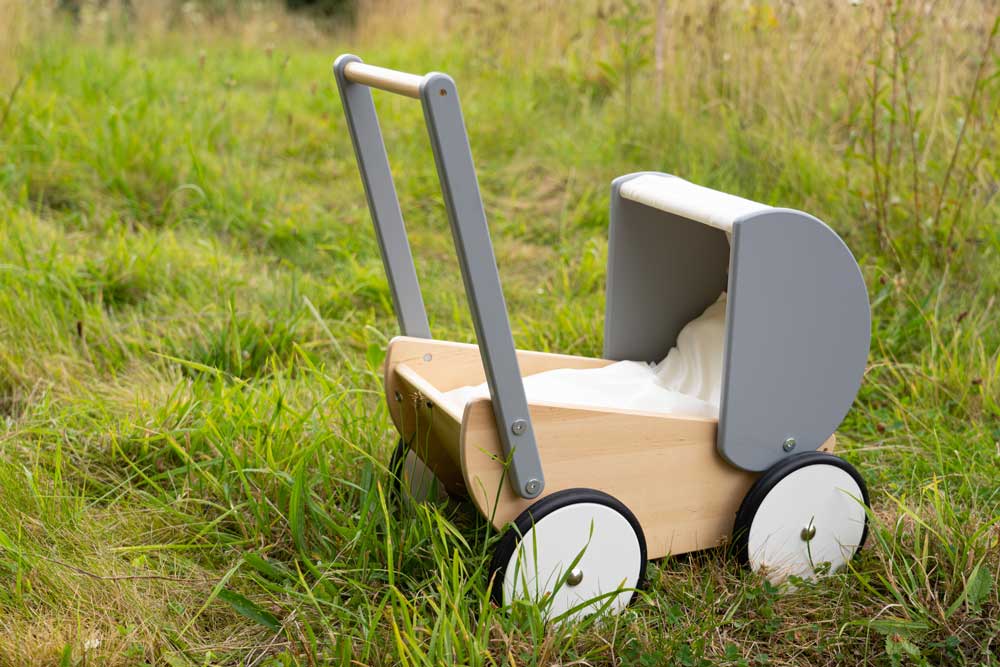 Bajo Monochrome wooden Doll's Pram outdoors on grass