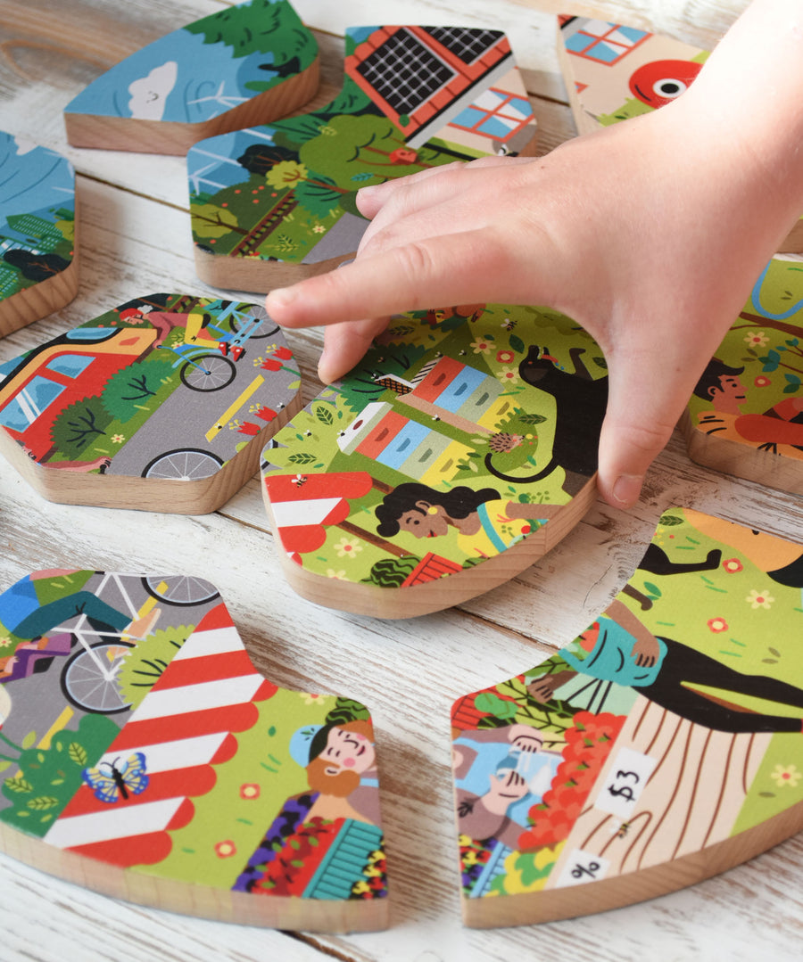 A close up of a child's hand holding a piece of the Bajo save our planet puzzle.