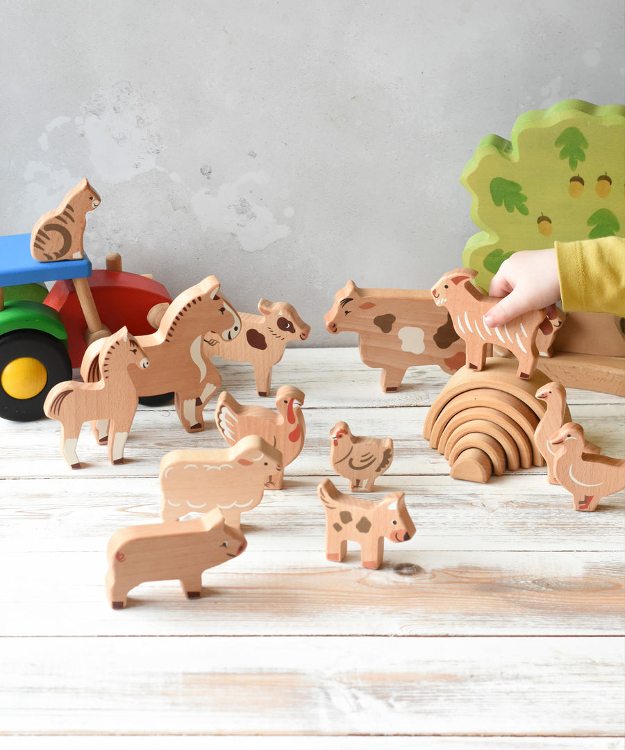 The figures from the Bajo farm animals set, set up in a play scene with a Bakop tractor and Holztiger oak tree in the background.