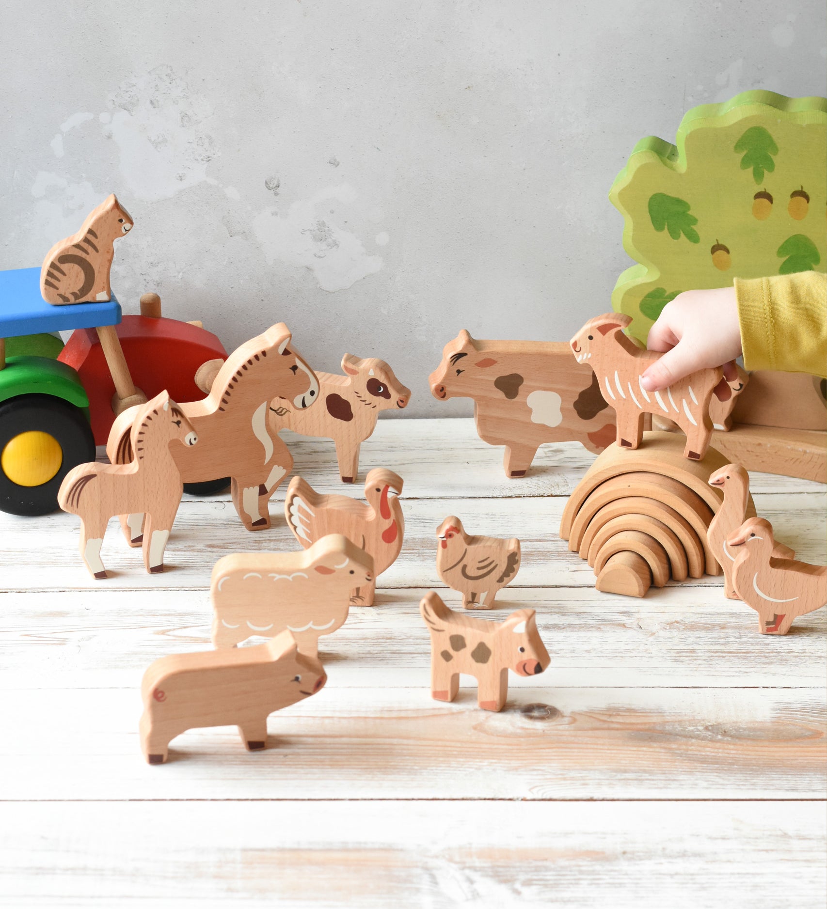 The figures from the Bajo farm animals set, set up in a play scene with a Bakop tractor and Holztiger oak tree in the background.