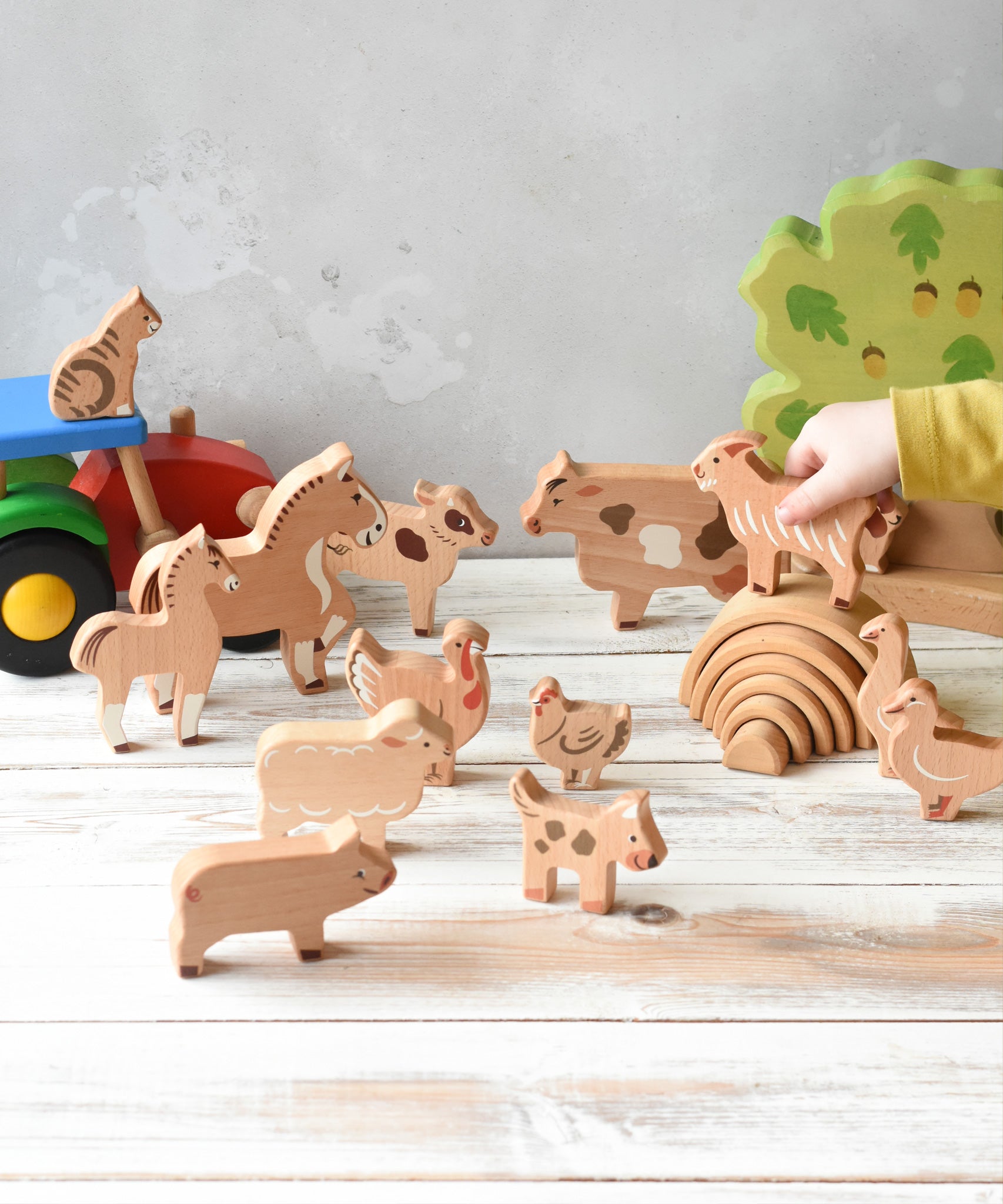 The figures from the Bajo farm animals set, set up in a play scene with a Bakop tractor and Holztiger oak tree in the background.