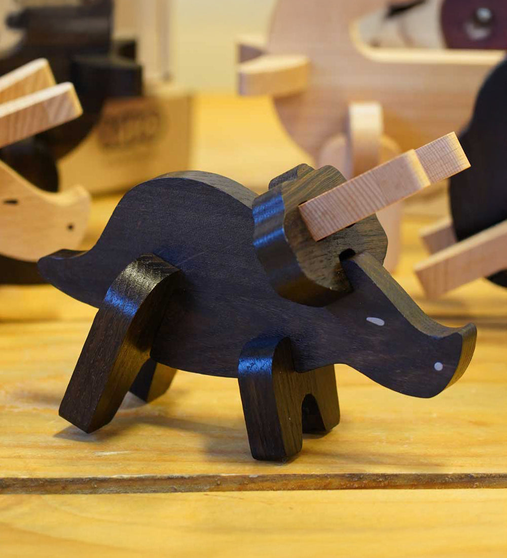 A built Bajo Puzzle & Sorter - Black Oak Triceratops stood on a wooden table