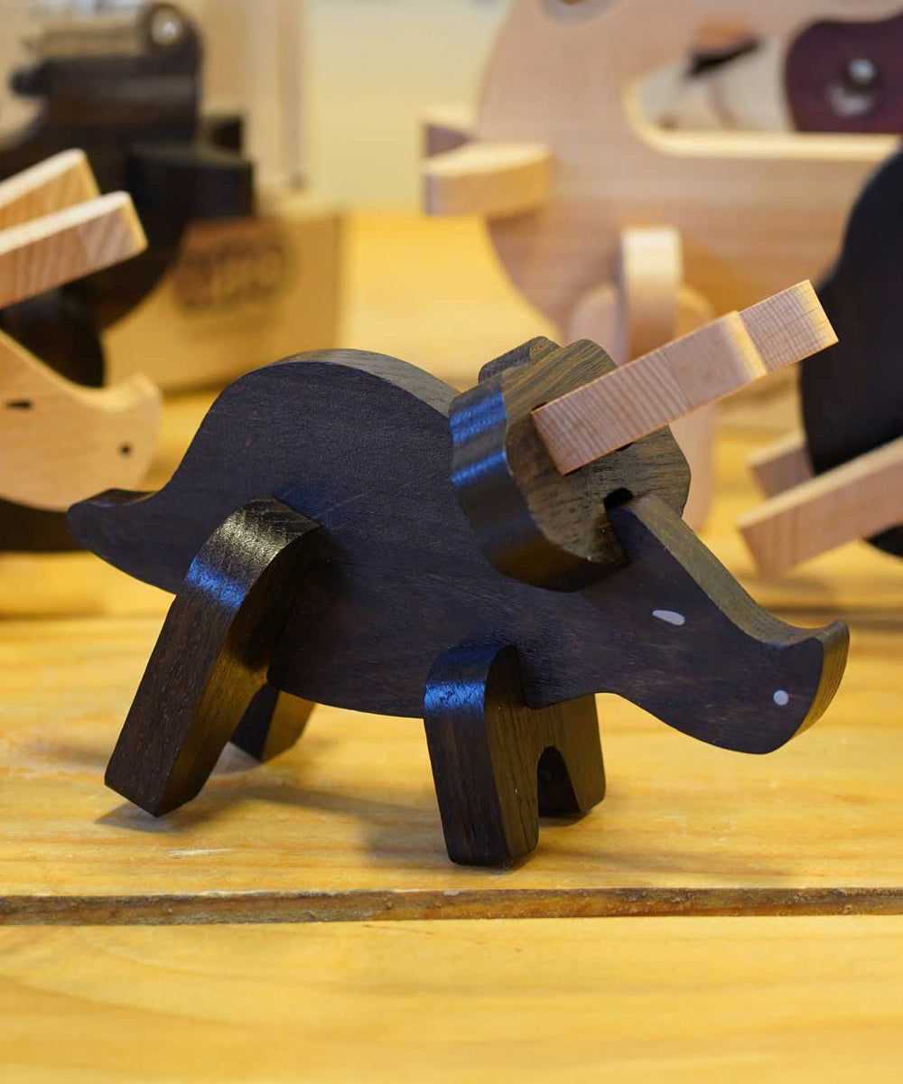 A built Bajo Puzzle & Sorter - Black Oak Triceratops stood on a wooden table