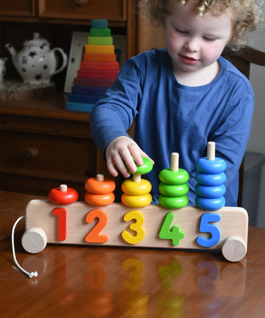 A child playing with a Bajo 1-5 pull along stacking toy