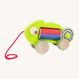 Bajo wooden pull chameleon toy in green with a pink pull cord and rainbow roller in the middle of the chameleon on a cream background