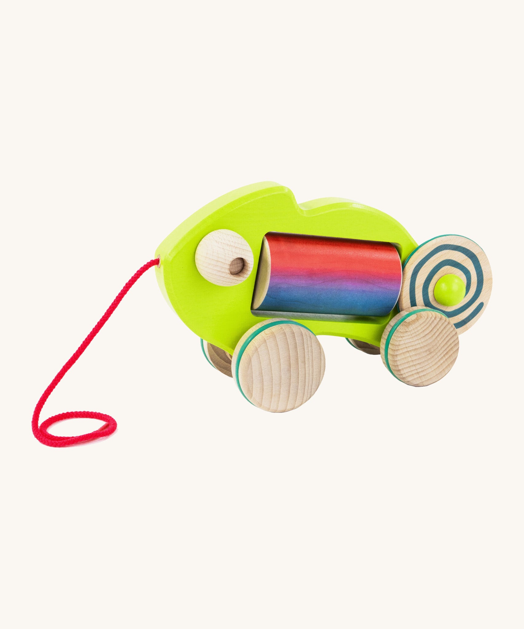 Bajo wooden pull chameleon toy in green with a pink pull cord and rainbow roller in the middle of the chameleon on a cream background