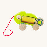 Bajo wooden pull chameleon toy in green with a pink pull cord and rainbow roller in the middle of the chameleon side detail on a cream background