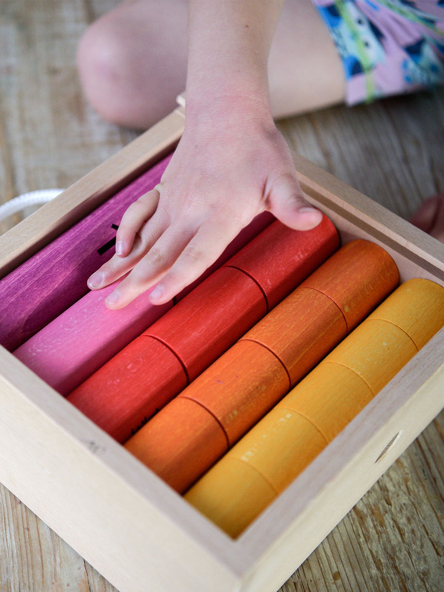 Bajo Fraction Set Maths Resource Learning Toy showing child's hand over the fraction blocks in a wooden box