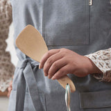 A Bambu Bamboo Rice Paddle  being held in a person's hand. 