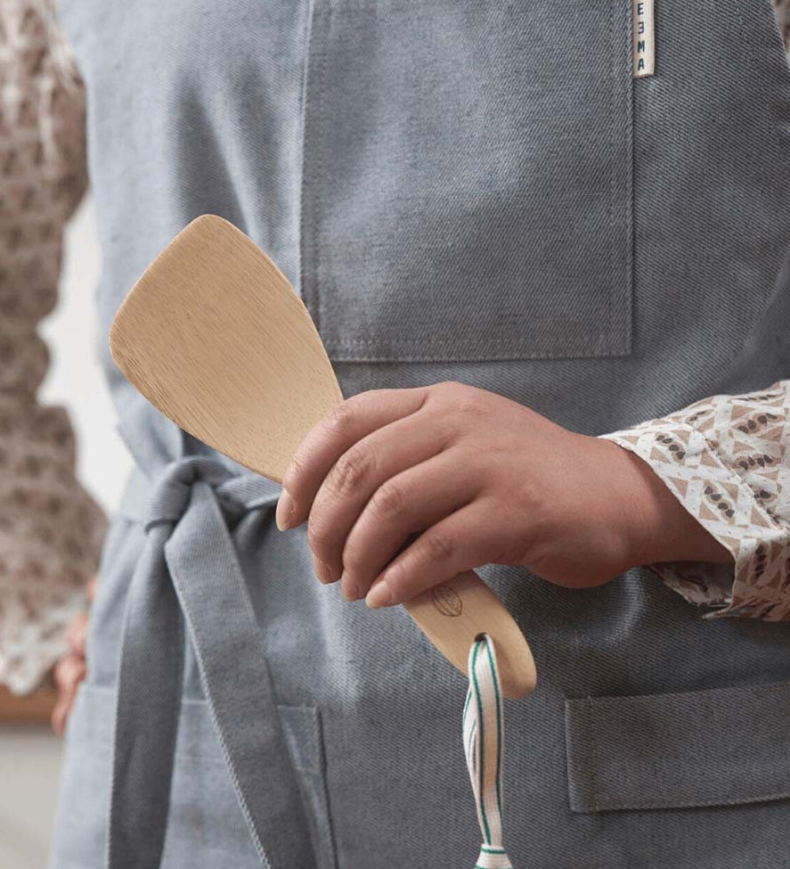 A Bambu Bamboo Rice Paddle  being held in a person's hand. 