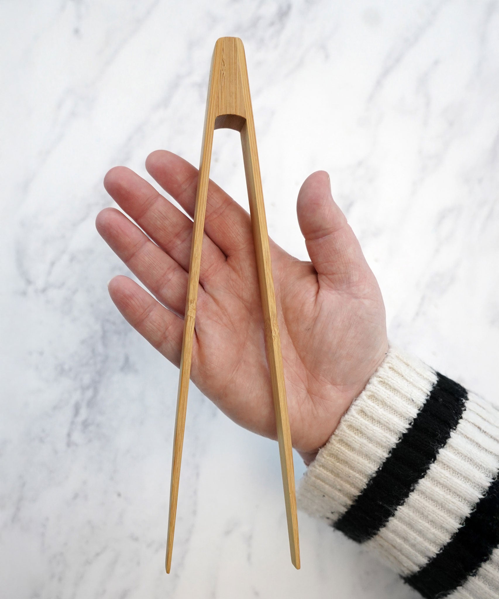 The Bambu small Tongs shown on a person's hand. 