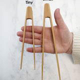 The Bambu Tiny and small Tongs shown on a person's hand. 