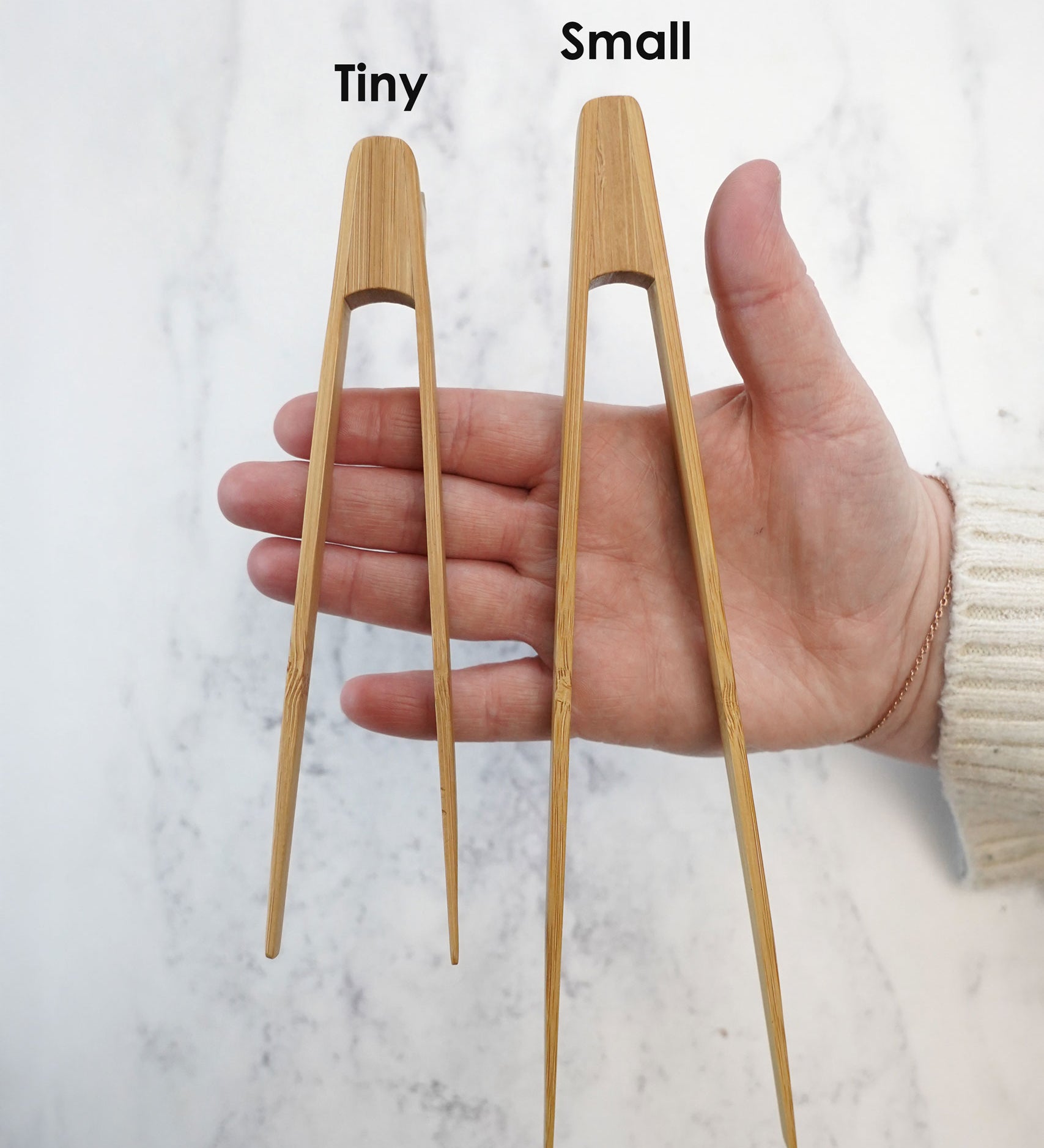 The Bambu Tiny and small Tongs shown on a person's hand. 