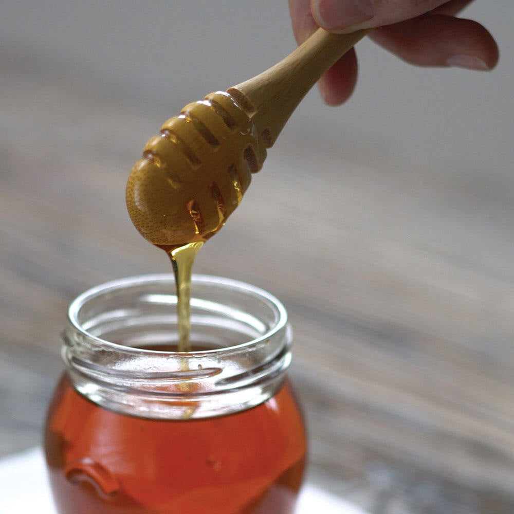 Bambu Bamboo Honey Dipper dipped in a jar of honey