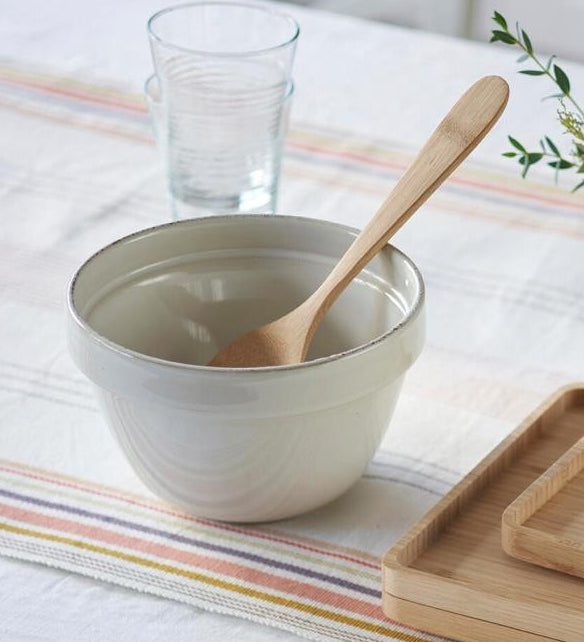 A Bambu Serving Spoon placed in an empty ceramic bowl.