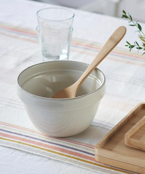 A Bambu Serving Spoon placed in an empty ceramic bowl.