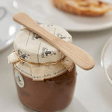 A Bambu bamboo Mini Spreader placed on top of a jam jar. 