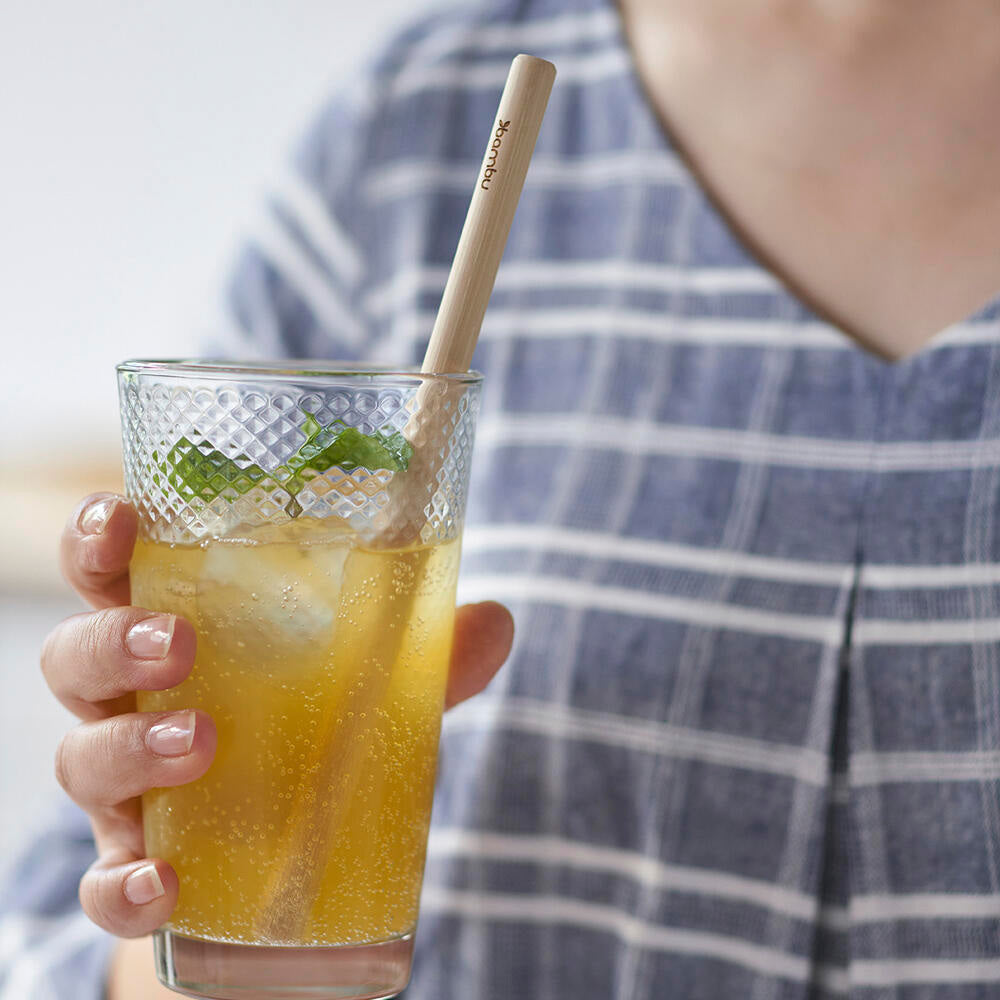 glass filled with sparkling drink with fresh mint and a bambu reusable straw