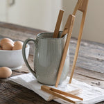 A collection of Bambu Bamboo tongs placed in a ceramic jug. 