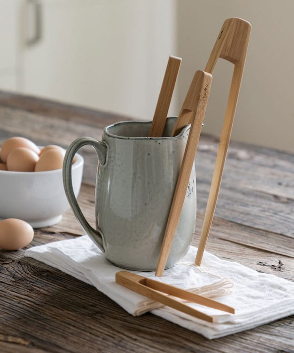 A collection of Bambu Bamboo tongs placed in a ceramic jug. 