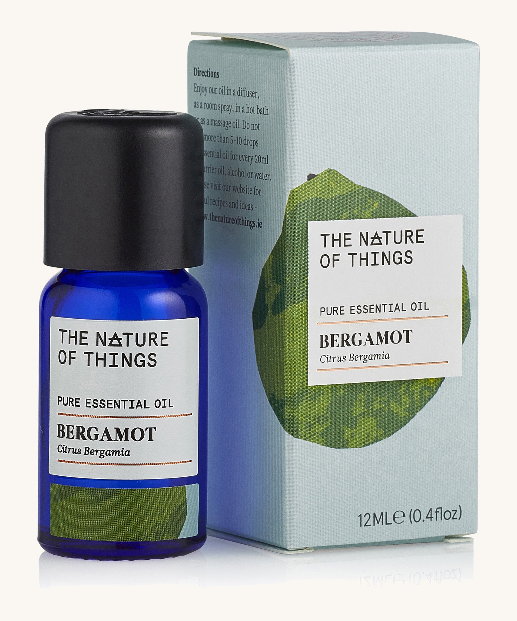 Bergamot pure essential oil in a blue glass bottle in front of a decorative blue cardboard box.