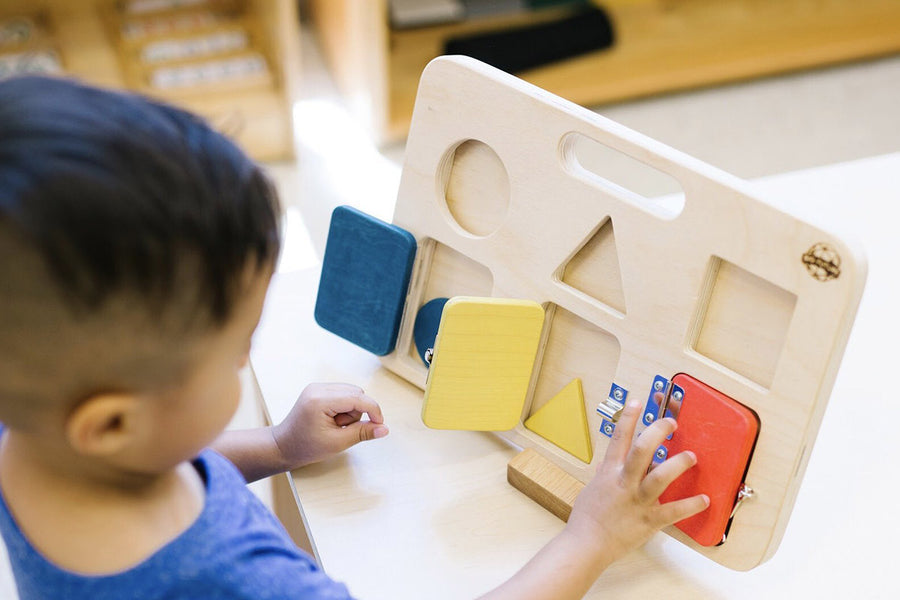 Child in a blue shirt opening the doors on a Big Future eco-friendly wooden latch board game