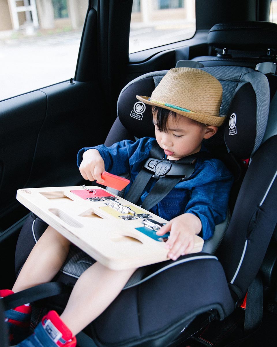 Child in a baby car seat wearing a brown hat