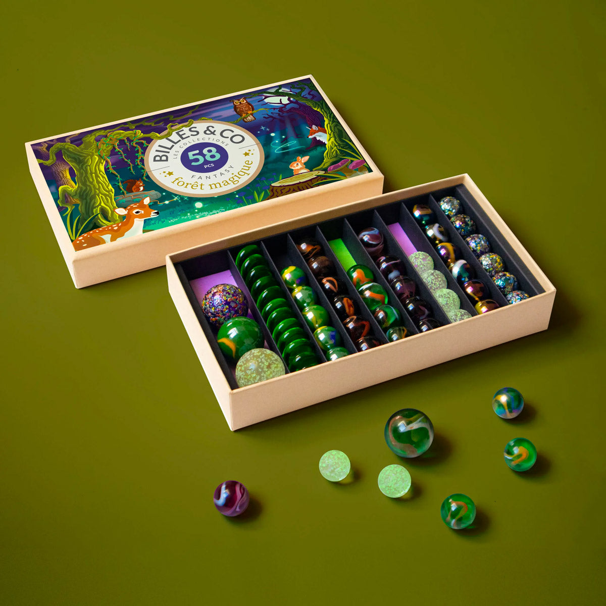 Billes & Co kids magic forest glass marbles laid out on a dark green background