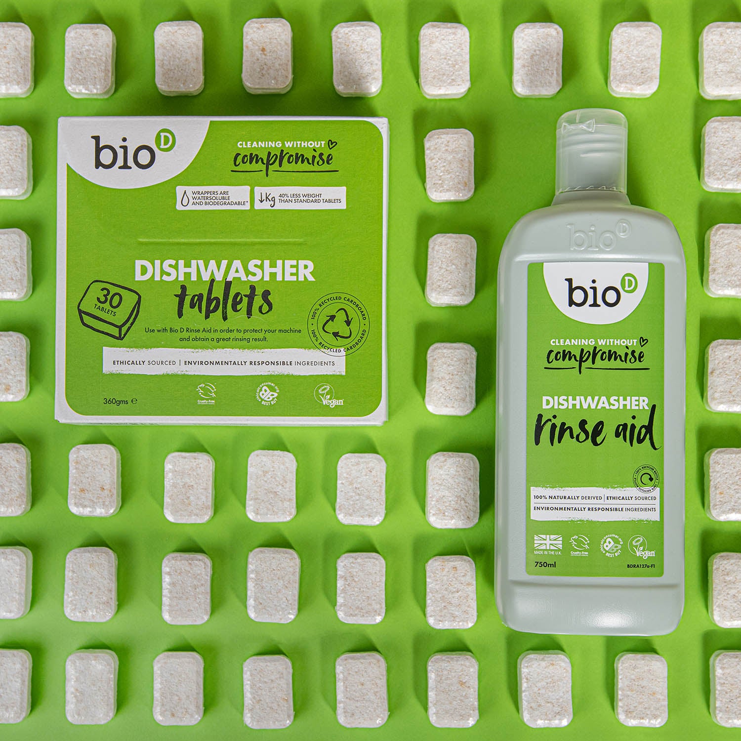 Box of Bio D eco friendly dishwasher tablets and bottle of Bio-D rinse aid on a green background