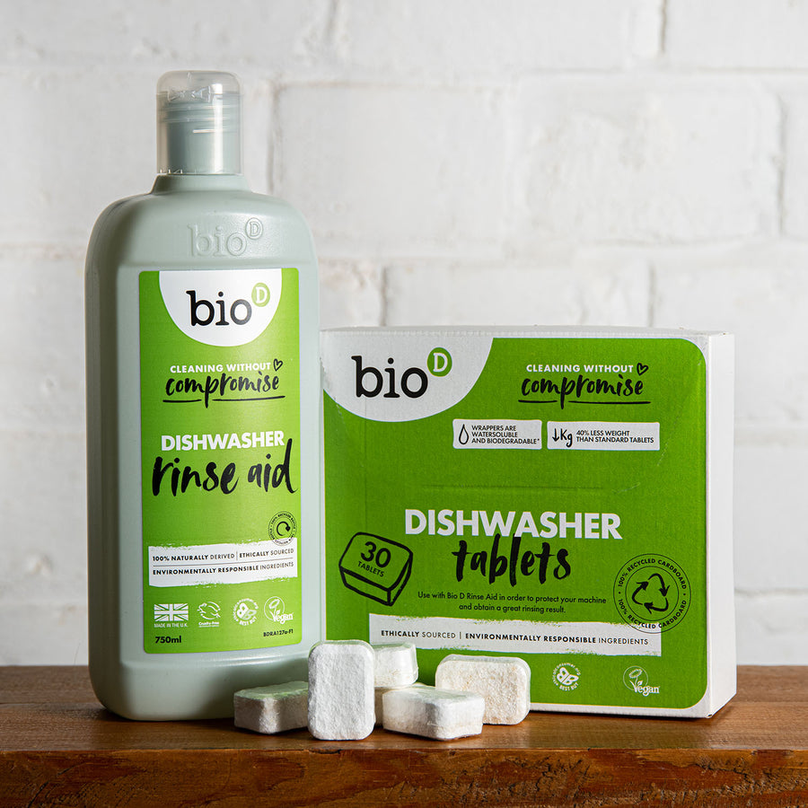 Box of Bio D eco friendly dishwasher tablets and bottle of Bio-D rinse aid on a green background