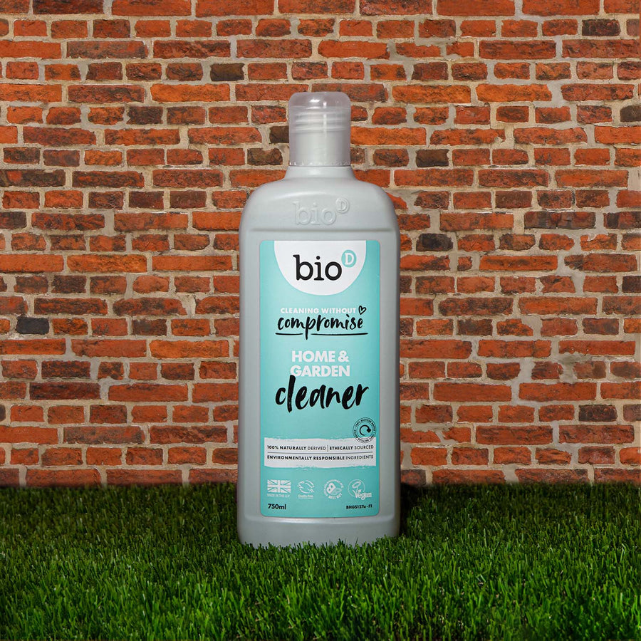 Bio-D Home & Garden Vegan Cleaner in a refillable 750ml bottle on a wooden table with white background and pine cones